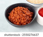 Tomato bolognese ragu with soya protein granules in bowl on gray background. Easy vegan soybean sauce for pasta