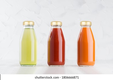 Tomato, carrot, green vegetable juices set in glass bottles with cap mock up in row on white wood table in light interior, template for packaging, advertising, design product, branding. - Powered by Shutterstock