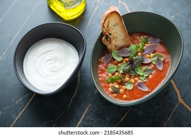 Tomato And Chickpea Soup With Fresh Basil And White Yogurt, Horizontal Shot On A Dark-olive Marble Background, Elevated View