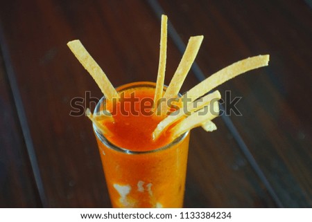 Tomato drink with tequila and toast strips in a glass of tequila.