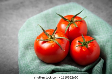 Tomato with drops. Full depth of field. Fresh red ripe tomatoes for use as cooking ingredients in the foreground with copyspace on dark background. Harvesting tomatoes. Top view