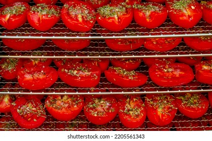 Tomato Halves Sprinkled With Herbs On Pallets For Drying.