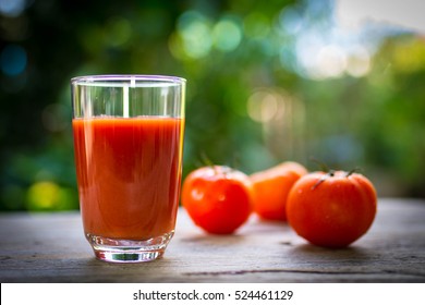 Tomato juice in clear glass on wooden table