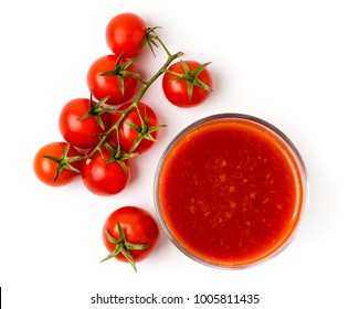 Tomato juice in a glass and a branch of red tomatoes on a white background.