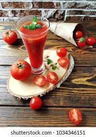   tomato juice and tomatoes on an aged wooden background with mint, in a glass or on a birch saw