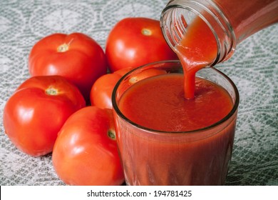 tomato juice with tomatoes on background
