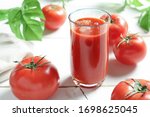 Tomato juice with tomatoes on the table