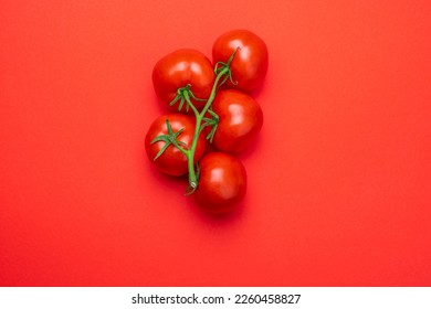 Tomato on a branch sprout top view flatlay on a red background. Fresh juicy ripe tomato Red Cherry fruits. Salad preparation ingredients. Empty copy space for mockup. - Powered by Shutterstock