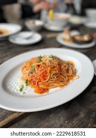 tomato pasta on wooden table - Shutterstock ID 2229618531