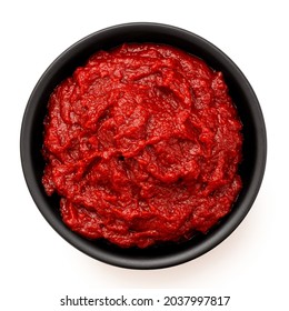 Tomato paste in a black ceramic bowl isolated on white. Top view.