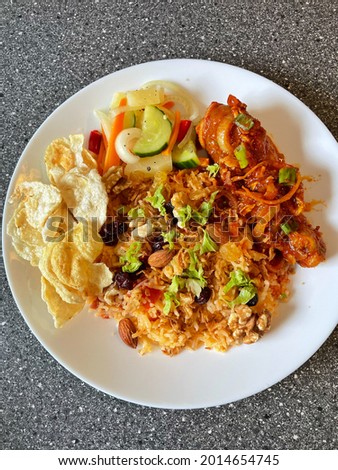 Tomato rice or also known as Nasi Tomato in Malaysia. Served with chilli chicken, cucumber salad and Belinjau chips.