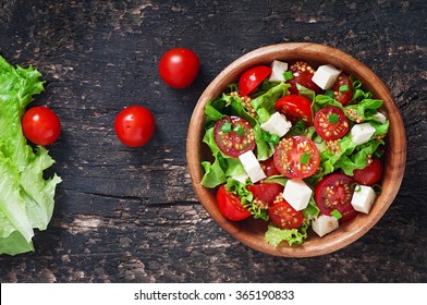 Tomato salad with lettuce, cheese and mustard and garlic dressing. Top view