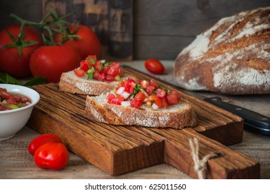 Tomato Salsa Sauce On Slices Of Bread Served On A Wooden Board. Rustic Style And Close Up.