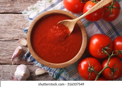 salsa de tomate con ajo y albahaca en un tazón de madera. vista horizontal desde arriba