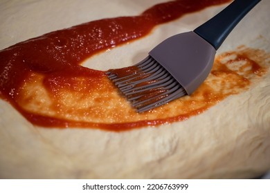 Tomato Sauce Spread With A Brush On A Pizza Dough