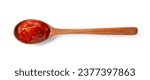 Tomato sauce in a wooden spoon on a white background. View from directly above.