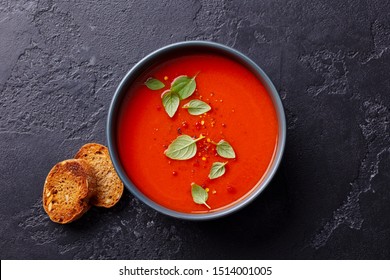 Tomato soup with basil in a bowl. Dark background. Close up. Top view. - Powered by Shutterstock