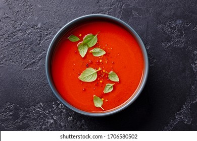 Tomato Soup With Basil In A Bowl. Dark Background. Close Up. Top View.