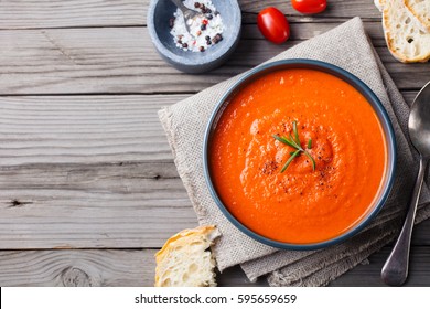 Tomato Soup In A Black Bowl On Wooden Background. Top View. Copy Space