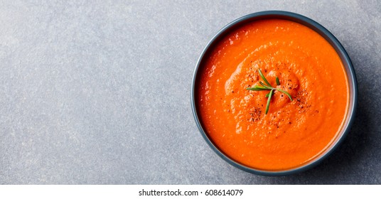 Tomato Soup In A Black Bowl On Grey Stone Background. Top View. Copy Space.