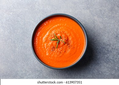 Tomato Soup In A Black Bowl On Grey Stone Background. Top View. Copy Space.