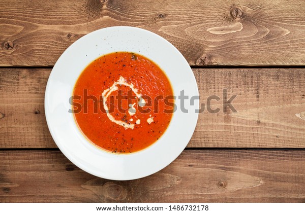 Tomato soup viewed from above. A classic comfort\
food, tomato soup is often enjoyed near summer end or fall. It is a\
simple and healthy soup using ripe tomatoes, broth and cream\
sometimes added.