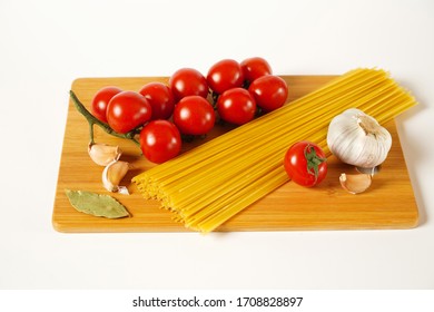 Tomatoes, garlic, pepper and spaghetti on the Board with white background - Powered by Shutterstock