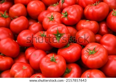 Tomatoes lying on a pile on top of each other, tomato texture. Selective focus.