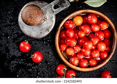 Tomatoes for marinating in a wooden plate. On a black background. High quality photo