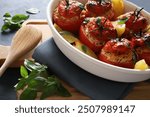 Tomatoes stuffed with rice and baked potatoes on gray background. Summer dish. Stuffed vegetables, Gemista. Greek cuisine. Directly above.