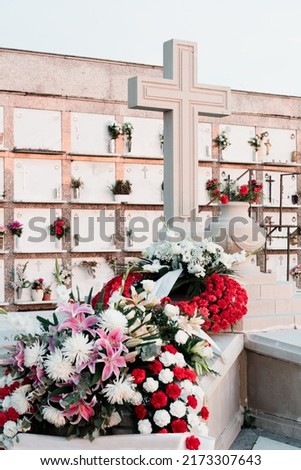 tomb with Christian cross and flowers in a cemetery. Niches and tombs in a cemetery.