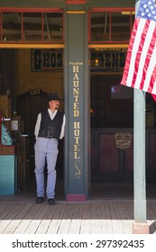 Tombstone, Arizona, USA, April 6, 2015, Cowboy And Flag In Old Western Town Home Of Doc Holliday And Wyatt Earp And Gunfight At The O.K. Corral