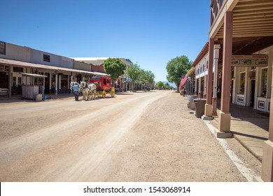Tombstone, Arizona, USA - May 1, 2019: Stagecoach passes the wild west style storefront facades down the dirt roads of the frontier turned tourist town of Tombstone, Arizona.
