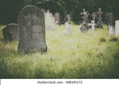 Tombstone and graves in an ancient church graveyard - Shutterstock ID 508109173