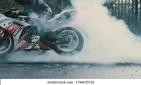 TOMSK, RUSSIA - May 16, 2020: Yamaha R1 in stickers and a pilot in overalls makes a burnout, a lot of smoke