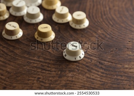 Tone knob. Electric Guitar knobs, Various electric guitar knobs on s old wooden work table. 