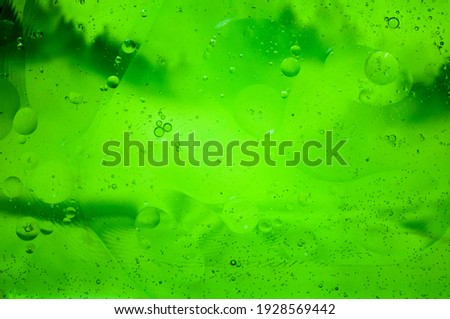 Tone, texture, design. On a green background bubbles of air on oil.