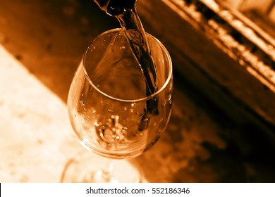 Toned Image. Thanksgiving Day. Christmas. Celebration. Pouring Red Wine. Wine In A Glass. Selective Focus, Motion Blur, Red Wine In A Glass. Sommelier Wine Into The Glass On A Blue Background Old.