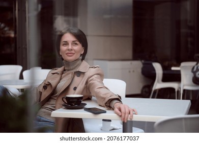 Toned Lifestyle Portrait Photography Of An Attractive Stunning Beautiful Young Elegant Woman In Stylish Casual Attire Resting In Outdoor Cafeteria, Enjoying Coffee Break