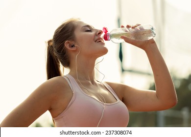 Toned Photo Of Beautiful Woman Drinking Water After Running At Hot Day