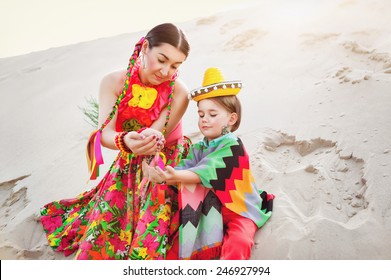 Toned Photo Of Happy Mom And Son Dressed In Mexican Clothes Play Sand