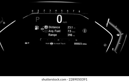 Toned photo illuminated instrument panel dashboard on new car with very low milage at only 23 miles odometer, digital display of gauges and indicators, fuel level, engine temperature. Modern driving
