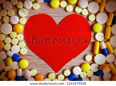 Toned Photo of Red Heart Shape with a Pills on the Table closeup