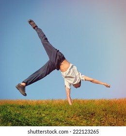 Toned Photo Of Somersault On Grass Of Teenage Boy