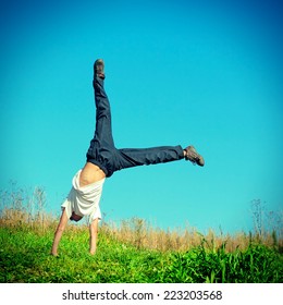 Toned Photo Of Somersault On Grass Of Teenage Boy