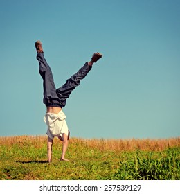 Toned Photo Of Somersault On The Grass Of Teenager