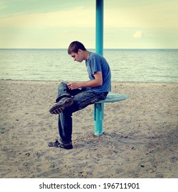 Toned Photo Of Teenager Reading The Letter On The Empty Beach