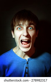 Toned Photo of Young Man yells in the Dark Room closeup