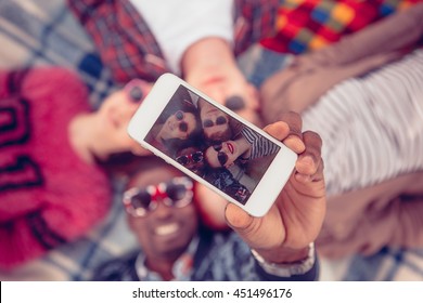 Toned. Picture of best friends making selfie on mobile or smart phone while spending free time on picnic in parkland. - Shutterstock ID 451496176
