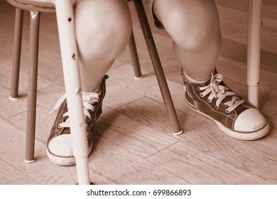 Toned Picture Of The Boy's Legs Under The Table In The Kindergarten.